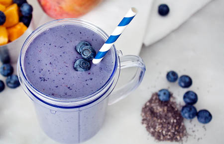 mango blueberry smoothie with chia seeds and fun straw