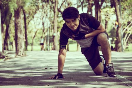 man struggling to get up after overtraining